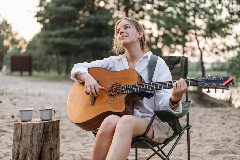 Woman Looking Up While Playing a Guitar